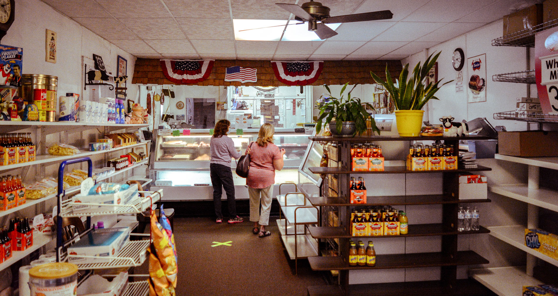 view of Dudek helping two customers select meats for their order
